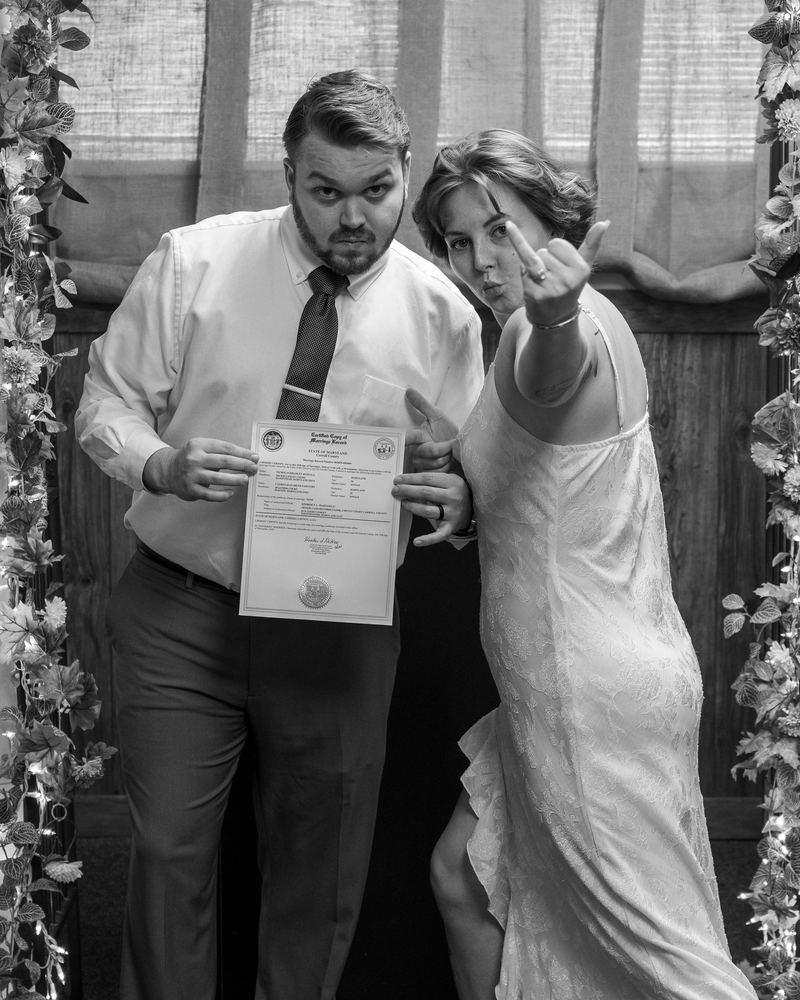 Bride and groom posing with their marriage certificate, playful wedding day portrait by Campbell Shepard, Frederick, MD