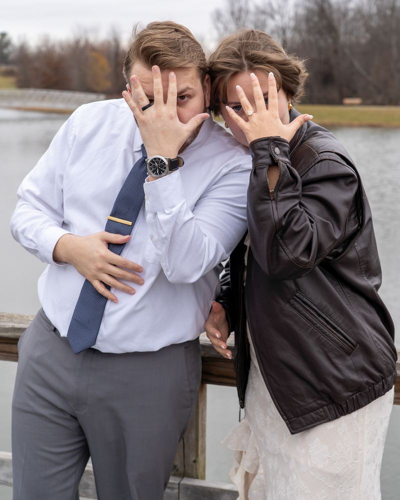 Playful engagement portrait of a couple showing off their rings by the water, Campbell Shepard photography, Frederick, MD