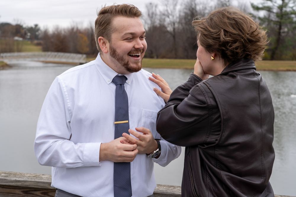 Couple laughing together just after getting engaged beside a Frederick area lake, photography by Campbell Shepard